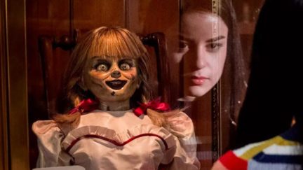 Spooky Annabelle doll being stared at by a child.