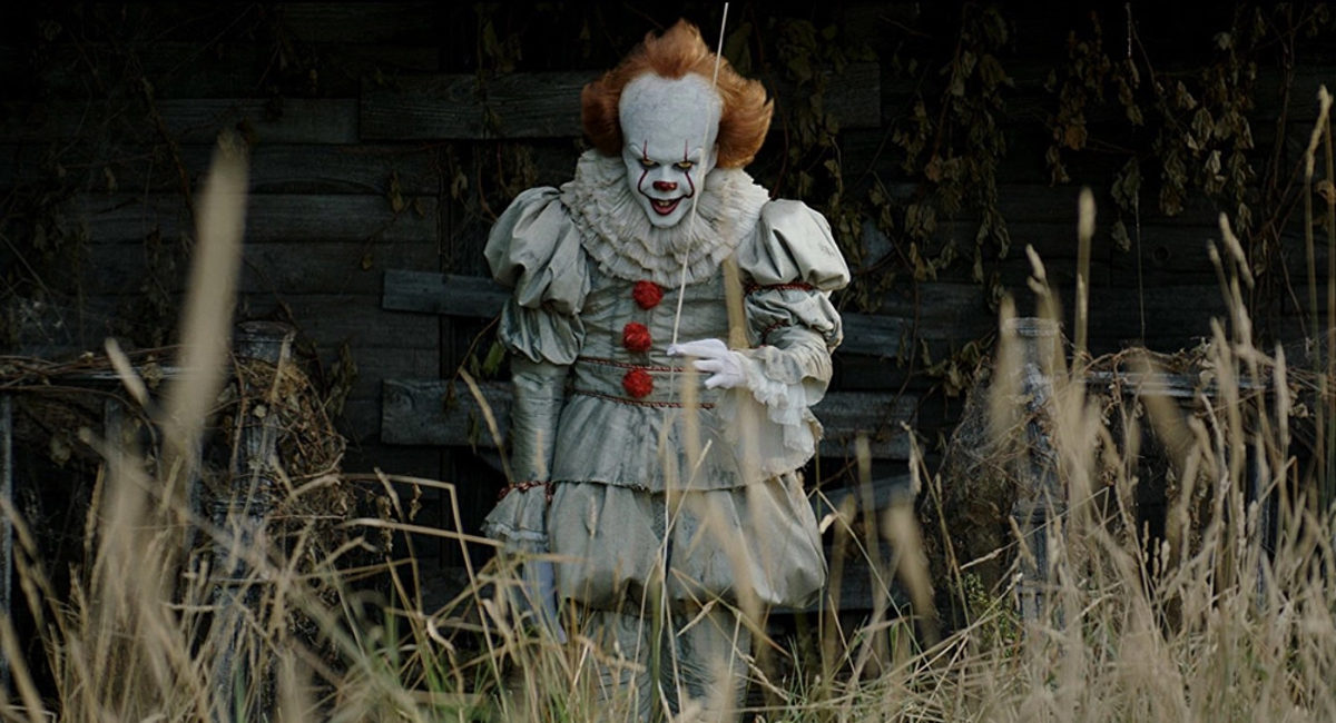 Pennywise (Bll Skarsgård) tries to catch a new victim in a still from IT: Chapter One.