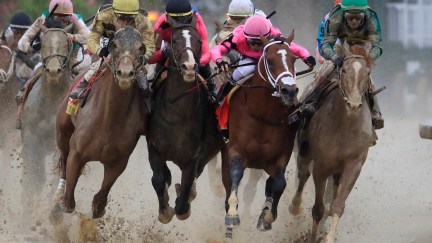 Horses race in the Kentucky Derby on a muddy track.