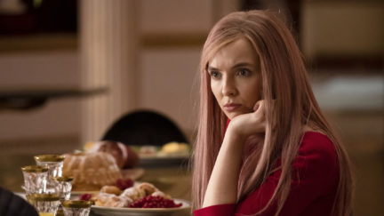 Villanelle (Jodie Comer) rests her chin in her hand, looking like she has questions too.