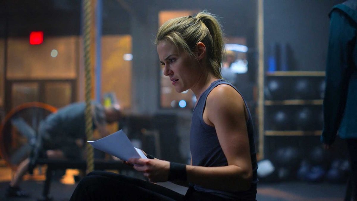 Trish sitting in the gym, holding a piece of paper in Marvel and Netflix's Jessica Jones season 3.