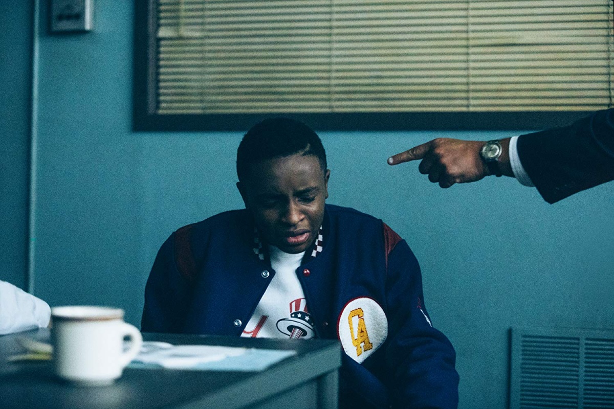 In 'When They See Us,' a young Black boy is distressed while being interrogated; a hand, belonging to someone out of frame, points in his face.