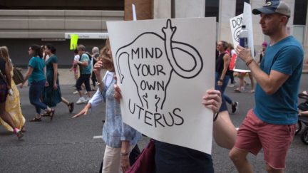 Pro-Abortion protest sign reading 'mind your own uterus'
