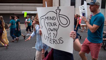 Pro-Abortion protest sign reading 'mind your own uterus'