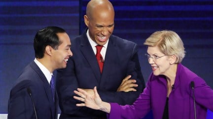 Julian Castro, Sen. Cory Booker (D-NJ) and Sen. Elizabeth Warren (D-MA) laugh together during the first night of the Democratic presidential debate