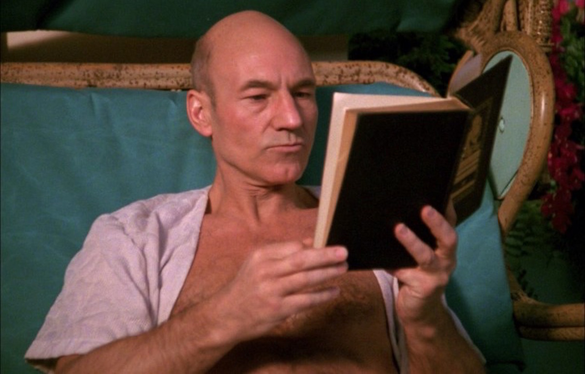 Captain Jean Luc Picard (Patrick Stewart) reads a book