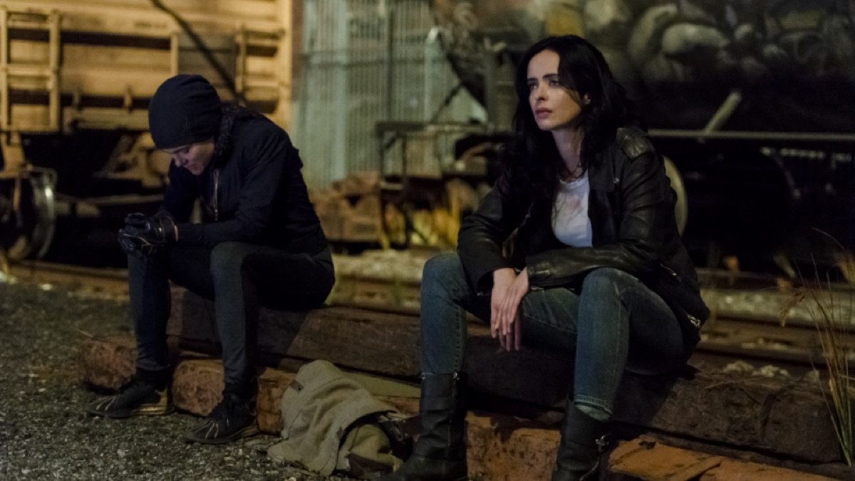 Trish and Jessica sit, looking unhappy and not looking at each other, in Marvel and Netflix's Jessica Jones season 3.
