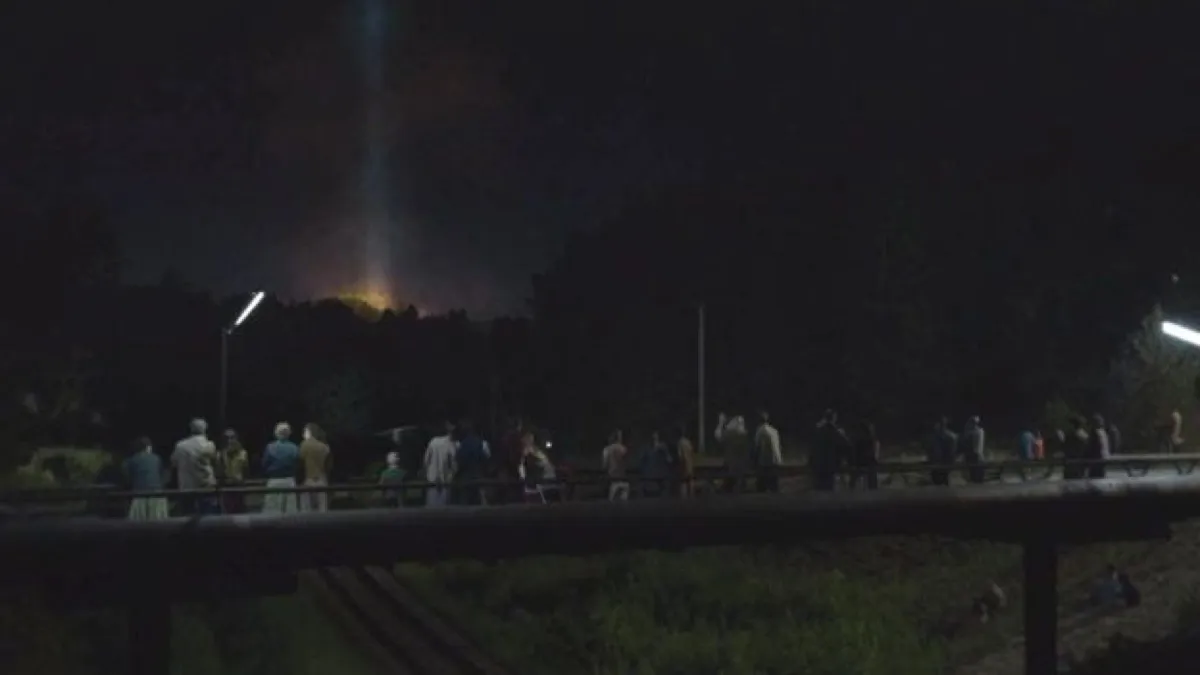 People overlook Chernobyl reactor fire from a bridge in HBO's Chernobyl.