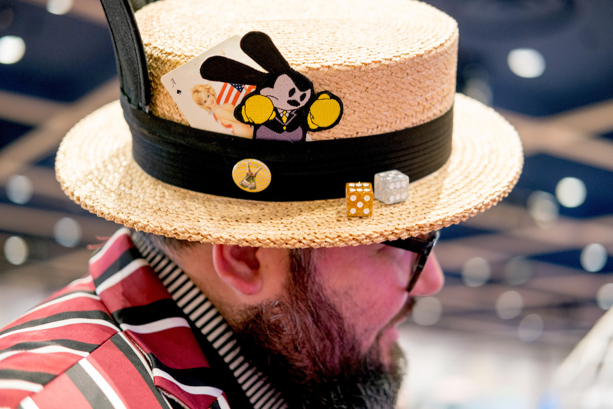 A man wears an old-fashioned straw hat with Disney details for Dapper Day.