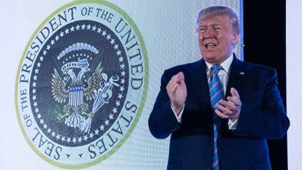 U.S. President Donald Trump stands next to a surreptitiously altered presidential seal as he arrives to address the Turning Point USAs Teen Student Action Summit.