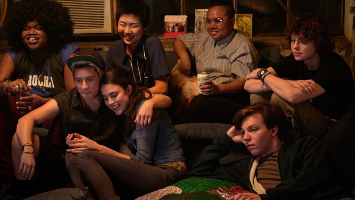 A group of people sitting around a TV together in the movie Adam.