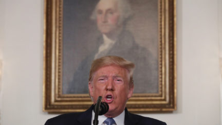 Donald Trump speaks in front of a portrait of George Washington.