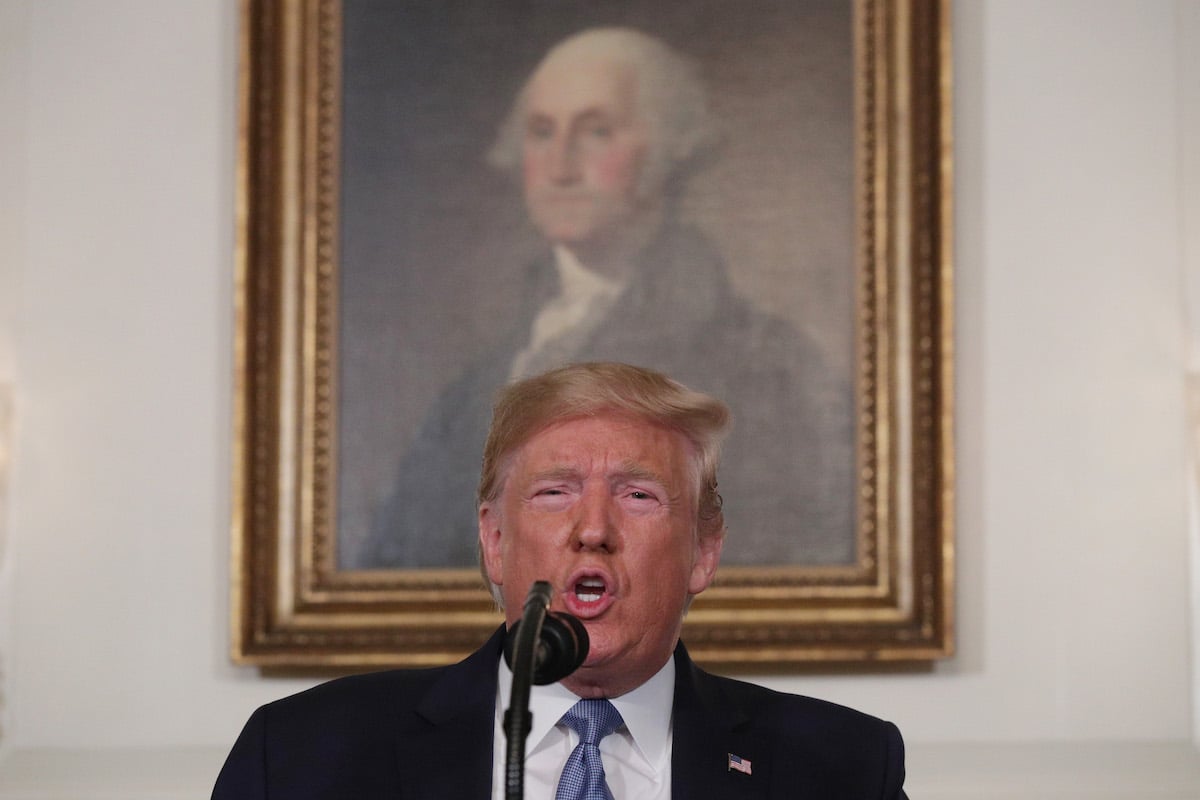 Donald Trump speaks in front of a portrait of George Washington.