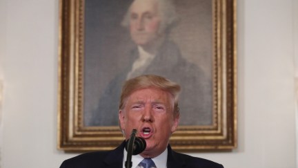 Donald Trump speaks in front of a portrait of George Washington.
