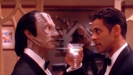Bashir and Garak in formal wear as Bashir lifts a martini glass to Garak in Star Trek: Deep Space Nine.