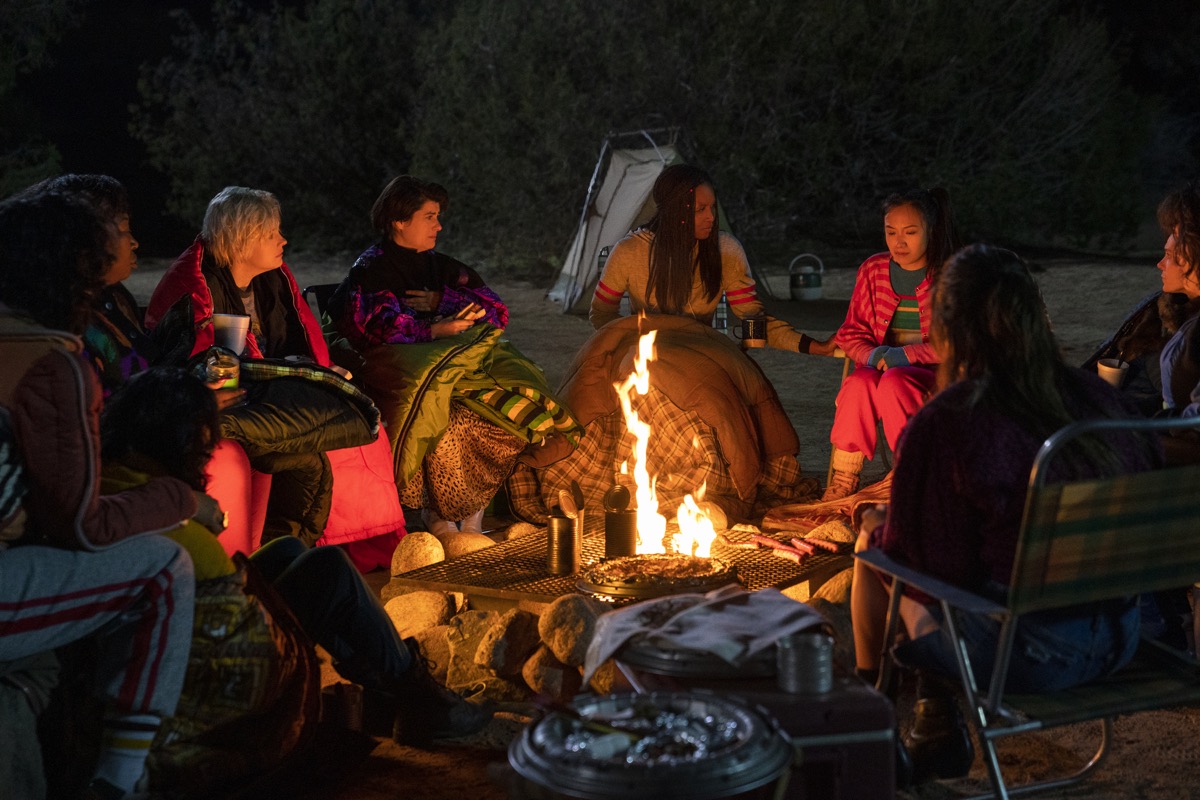Glow season 3 cast sitting around campfire.