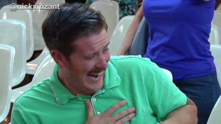 A man in a green shirts laughing.