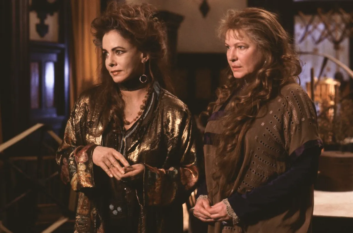stockard channing and dianne wiest in practical magic, standing in flowing clothing in their house.