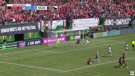 Anti-fascist protest signs hang in the stadium during a women's soccer game.