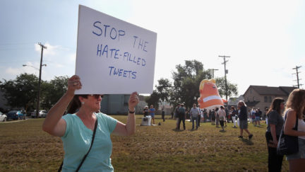 An anti-Trump protester holds a sign reading 