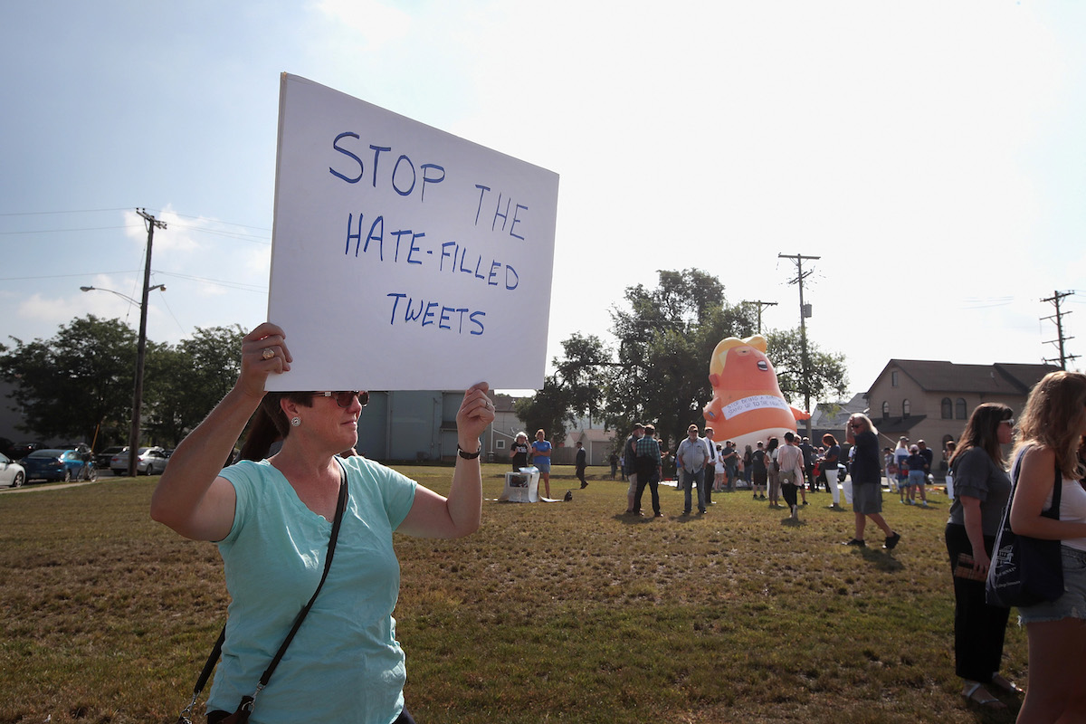 An anti-Trump protester holds a sign reading "stop the hate-filled tweets."