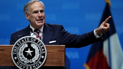 Texas Governor Greg Abbott speaks from a podium at an NRA convention.