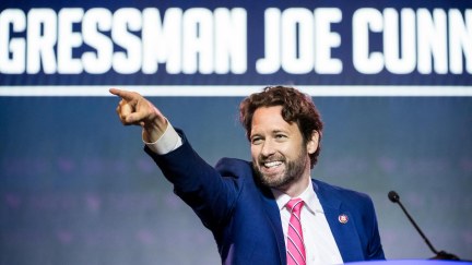 Joe Cunningham points to the crowd from a podium with his name projected behind him.