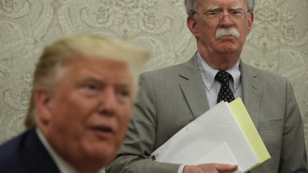 John Bolton frowns as Trump makes weird faces at reporters.
