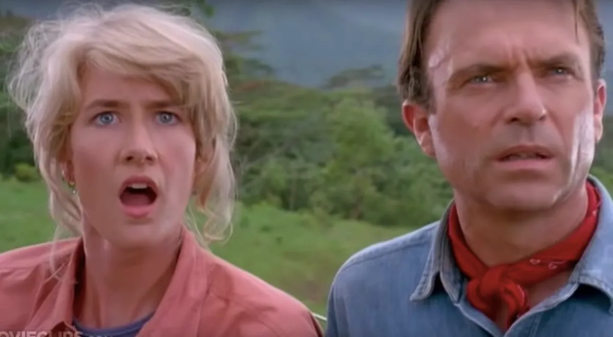 Sattler and Grant looking surprised as they stare at dinosaurs for the first time in Jurassic Park.