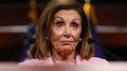 Nancy Pelosi in a pink suit with eyebrows raised.