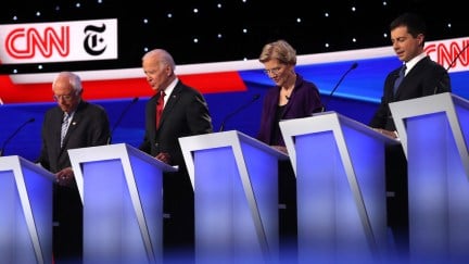 Bernie Sanders, Joe Biden, Elizabeth Warren, and Pete Buttigieg stand at their podiums on the stage of the fourth Democratic debate.