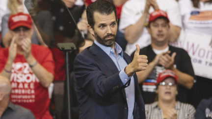 Donald Trump Jr. gives a thumbs up from the stage of his daddy's rally.