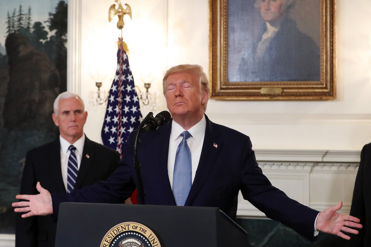 Trump makes Jesus arms as Mike Pence looks on in front of George Washington's portrait.