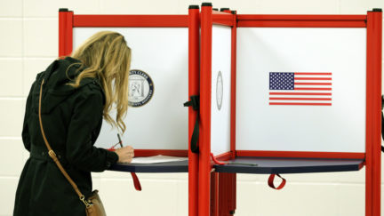 Female voter fills out a ballot on election day.