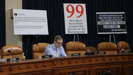 Rep. Jim Jordan sits alone in a Capitol Hill hearing room in front of a bunch of stupid giant signs.