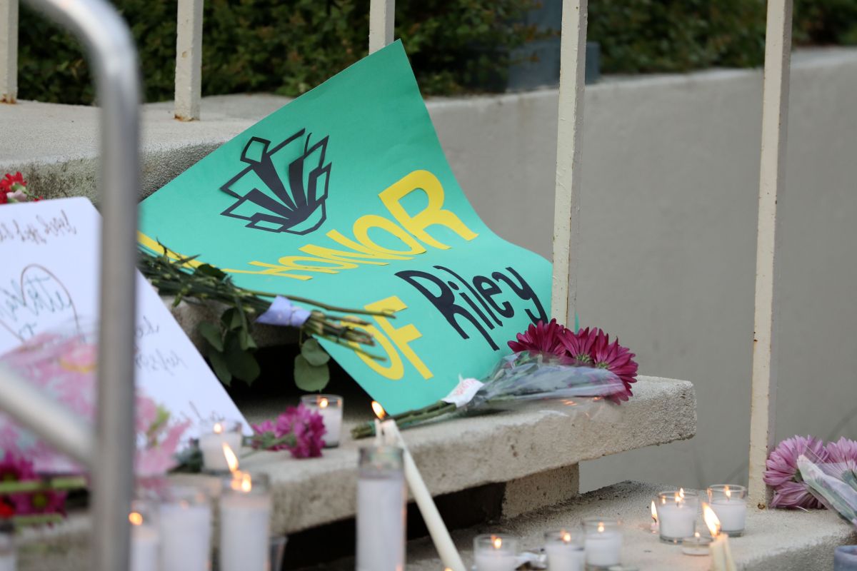 Students lay candles and flowers at the steps of Kennedy Hall to honor the victims of a shooting the day earlier at the University of North Carolina Charlotte, in Charlotte, North Carolina on May 1, 2019. - A 21-year-old student gave his life to save others by tackling a gunman who was shooting up a university classroom, police in the US said May 1, 2019. Charlotte-Mecklenburg Police Chief Kerr Putney said the authorities were still trying to find a motive for Tuesday's attack at the University of North Carolina, which left undergraduate Riley Howell and another student dead. (Photo by Logan Cyrus / AFP) (Photo credit should read LOGAN CYRUS/AFP via Getty Images)