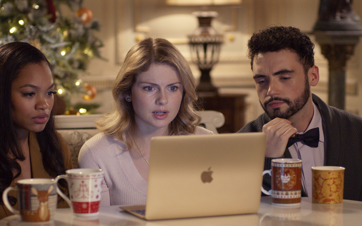 Amber and her friends from A Christmas Prince sit around her laptop looking concerned.
