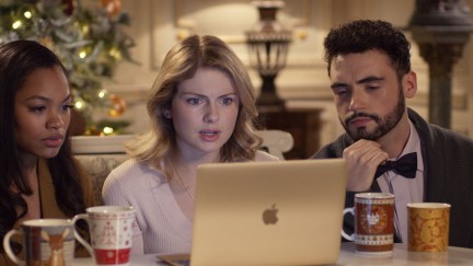 Amber and her friends from A Christmas Prince sit around her laptop looking concerned.
