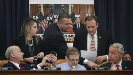 Republican lawmakers huddle together during an impeachment hearing debate.