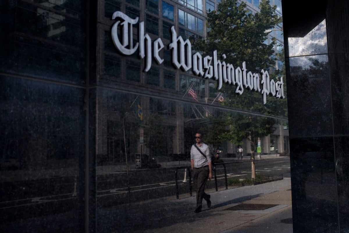 A man walks past The Washington Post on August 5, 2013 in Washington, DC after it was announced that Amazon.com founder and CEO Jeff Bezos had agreed to purchase the Post for USD 250 million. Multi-billionaire Bezos, who created Amazon, which has soared in a few years to a dominant position in online retailing, said he was buying the Post in his personal capacity and hoped to shepherd it through the evolution away from traditional newsprint. AFP PHOTO/Brendan SMIALOWSKI (Photo credit should read BRENDAN SMIALOWSKI/AFP via Getty Images)
