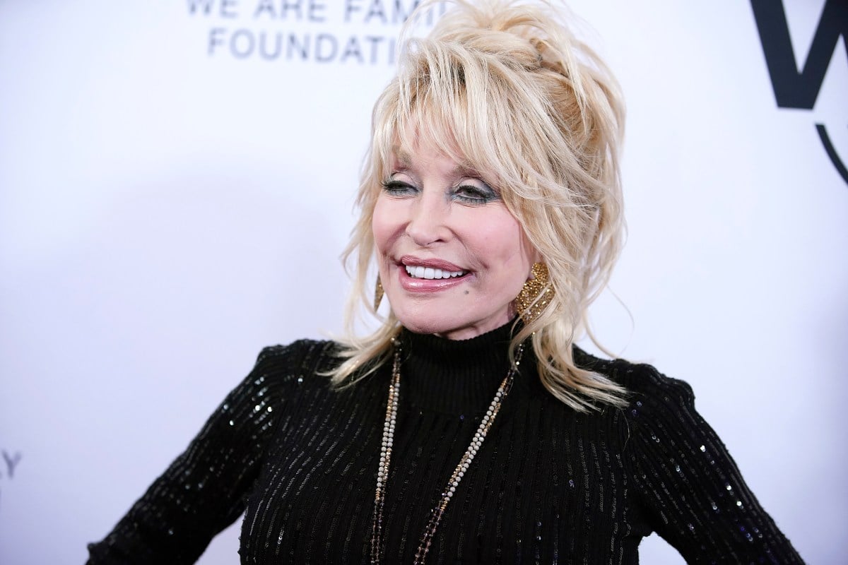 dolly parton grins on a red carpet