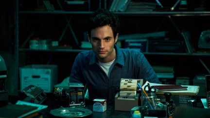 Penn Badgley as Joe, sitting behind his basement desk in Netflix's You.