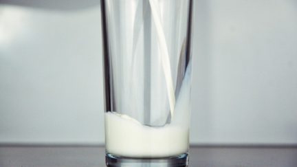 A glass of milk being poured.