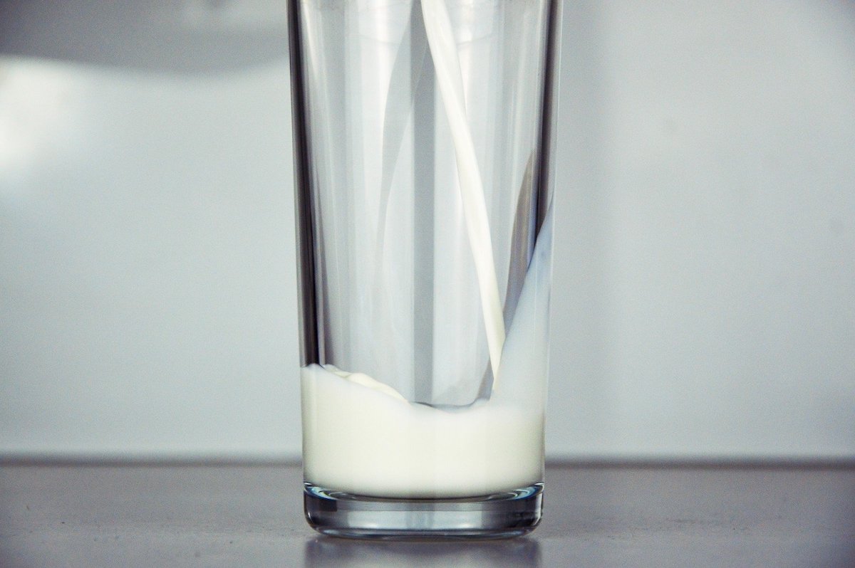 A glass of milk being poured.