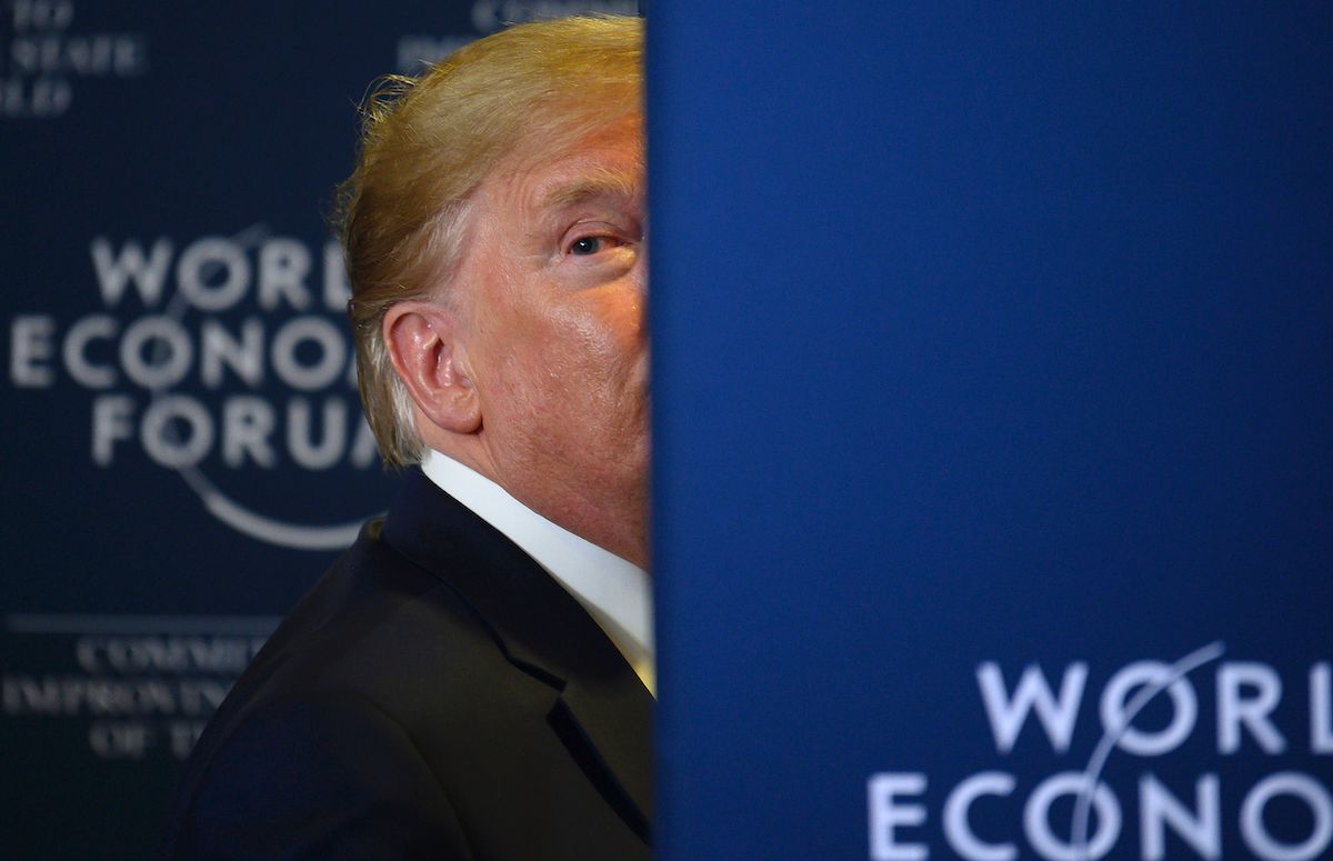 Trump peeks out from behind a wall at the World Economic Forum.