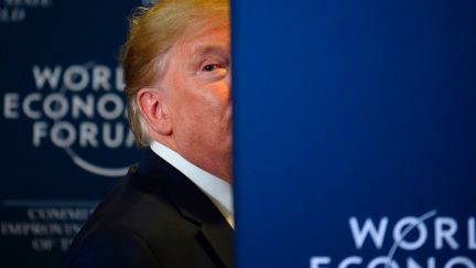 Trump peeks out from behind a wall at the World Economic Forum.