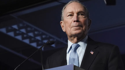 Mike Bloomberg stands at a podium.