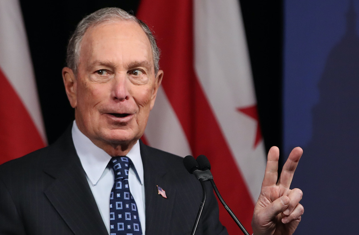 Michael Bloomberg holds up two fingers for the number of hundreds of millions of dollars he's spent on his presidential campaign so far.