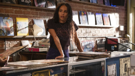 High Fidelity's Rob (Zoe Kravitz) leans on the counter of her record shop.