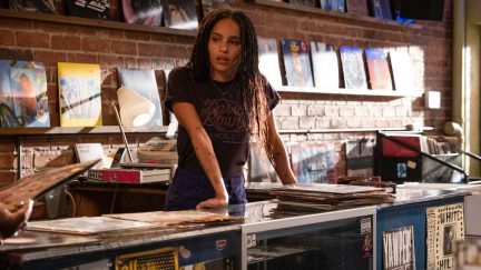 High Fidelity's Rob (Zoe Kravitz) leans on the counter of her record shop.